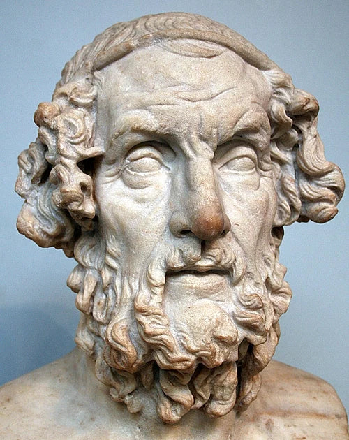 Ancient marble bust of Homer, the legendary Greek poet, featuring a detailed beard, curly hair, and classical sculpture style displayed in the British Museum.